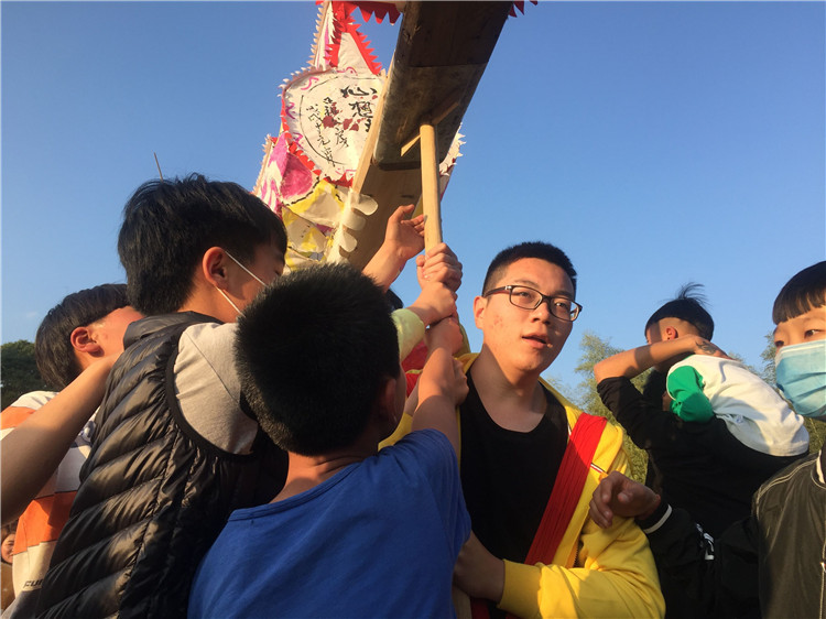 20180302福建高校学生记者采访客家年俗 图为学生记者体验“姑田游大龙” 林响.jpg