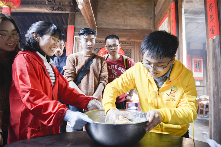 20180228福建高校学生记者采访客家年俗 图为学生记者在体验制作年糕 林响.JPG