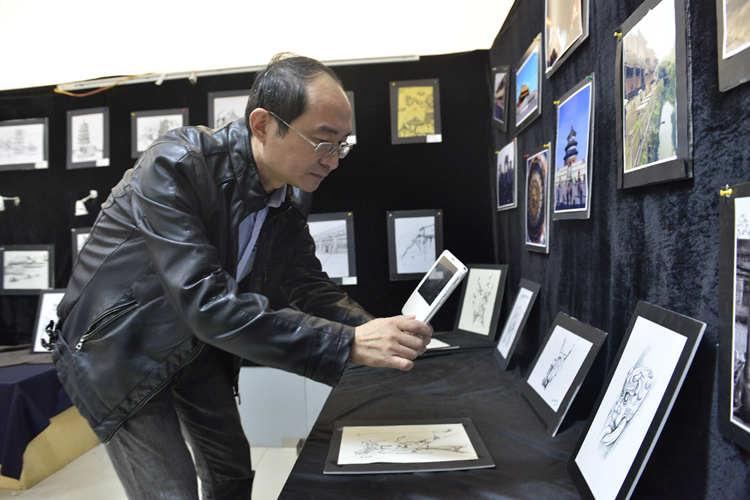 前来参展的袁勇麟院长拿起手机不住地拍照1.jpg