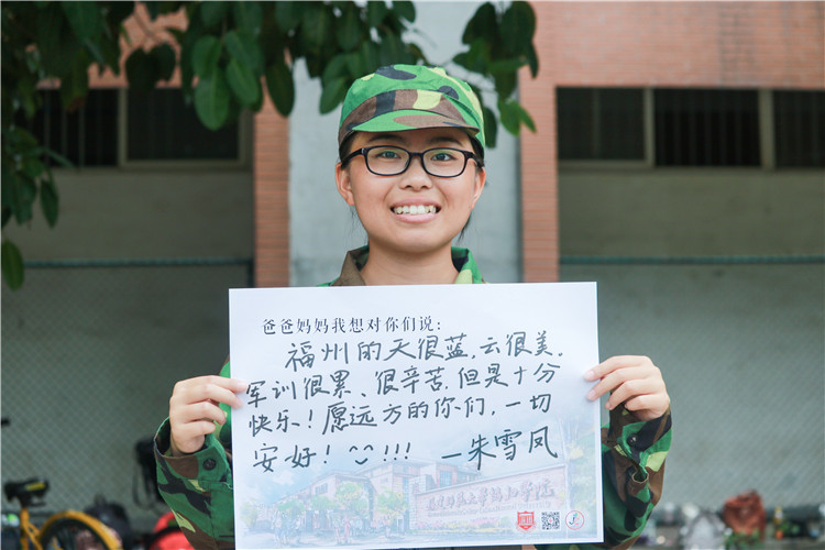 国际商学系国际贸易专业朱雪凤同学通过举牌回复家书的方式思念家人 龚月摄