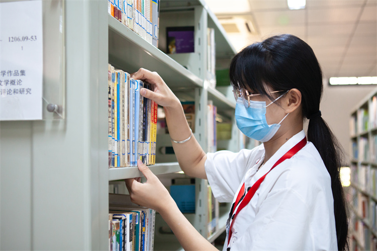 20220423开云手机入口第十三届读书节 学习资源中心勤工助学管理员正在将书按顺序摆放整齐 刘梦卿摄.jpg