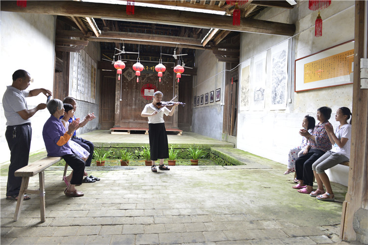 志愿者为当地居民演奏小提琴.JPG