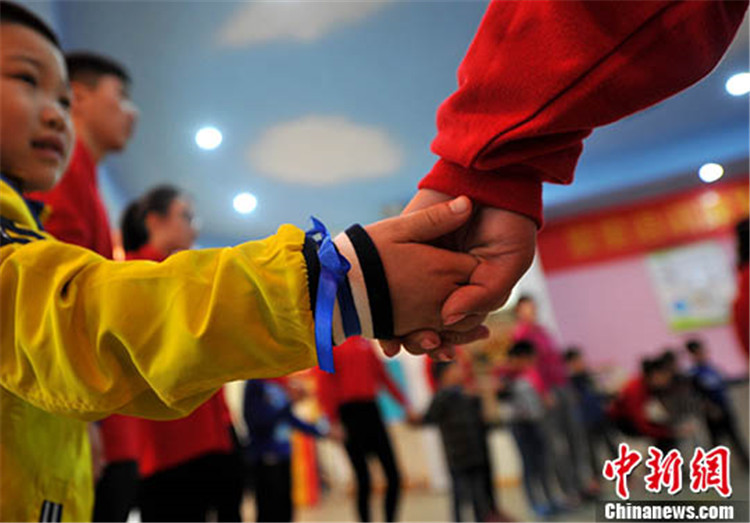 福州青年会志愿者和患有自闭症的孩子在一起交流 中新社记者 张斌 摄.jpg
