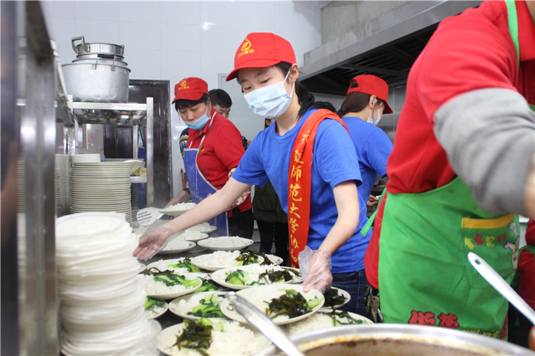 大学生志愿者为就餐师生打饭.JPG