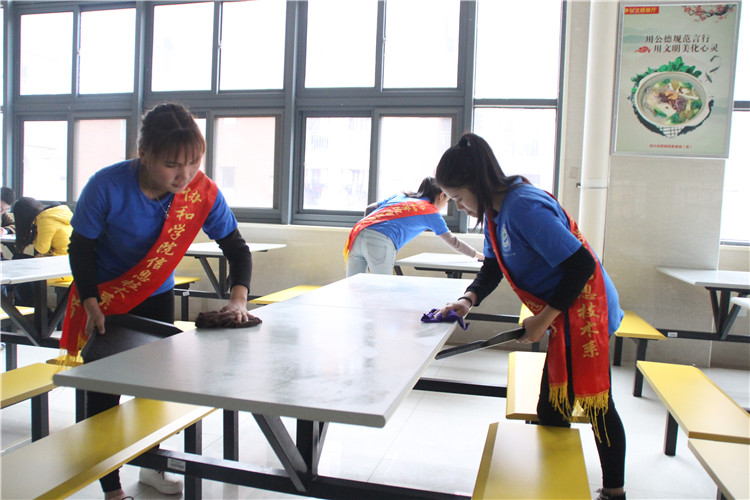 大学生志愿者正在擦洗餐桌.JPG