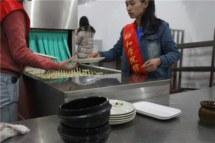 大学生志愿者正在清理餐盘.jpg