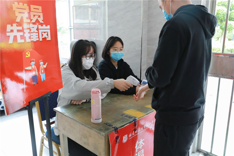1、学生党员在宿舍楼下进行测温工作.jpg