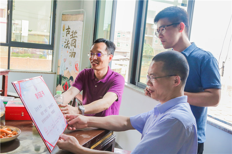 20180706 吴华清向陈晓斌书记和林志达书记展示古法酱油所获荣誉 林小毳摄.JPG